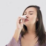 Asian women in satin nightwear with nosebleed against gray Background The asian people hurts her nose transformed