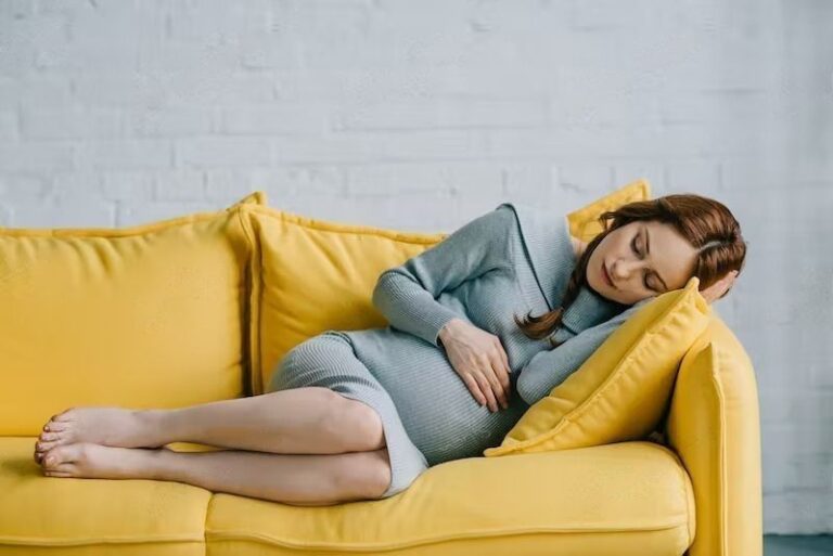 beautiful pregnant woman sleeping on yellow sofa at home transformed