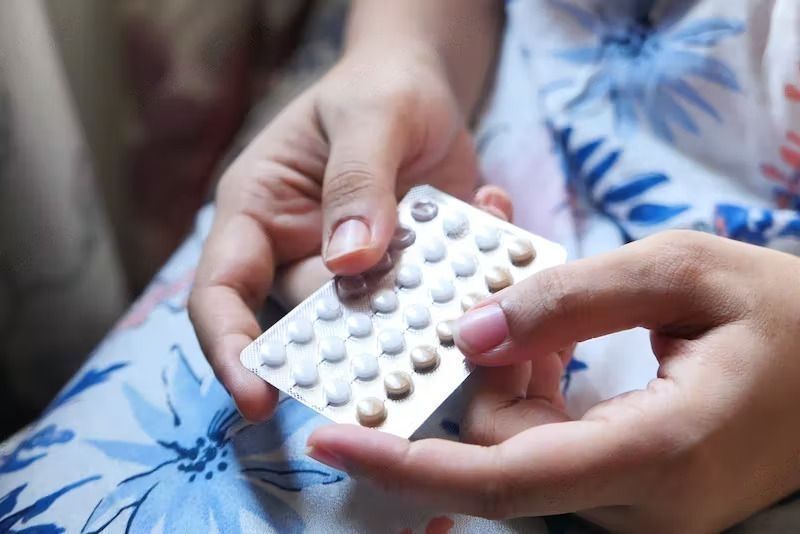 When to Stop Birth Control Pills Before Pregnancy? A woman holding birth control pills