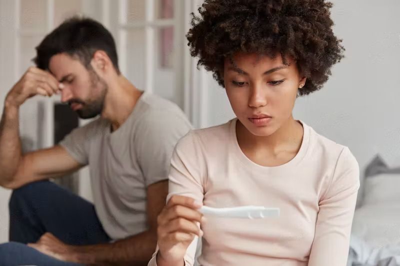 Why Pregnancy Not Happening? 14 Possible Reasons - A woman looks at pregnancy test, suffers from infertility