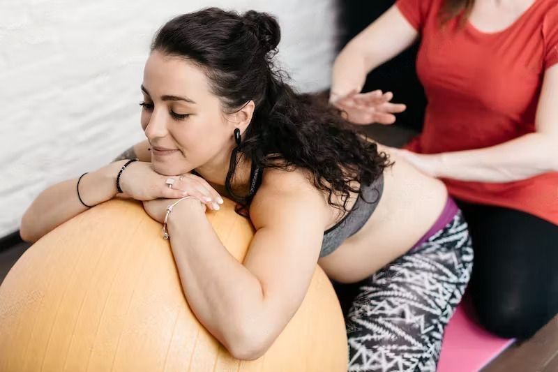 Can A Postnatal Massage Help You To Lose Weight? A pregnant woman getting a back massage from her midwife