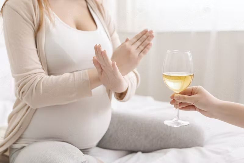 Should You Drink Alcohol during Pregnancy? - A pregnant woman with crossed hands refusing to drink alcohol.