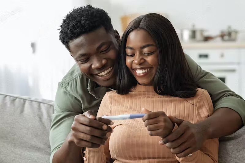 Preparing for Pregnancy – What to Expect and How to Handle? A happy couple looking at positive pregnancy test strip