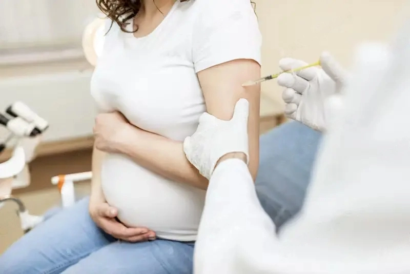 Flu Vaccine During Pregnancy - A pregnant woman getting vaccine injection 