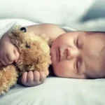 sleeping baby with a stuffed toy transformed 1
