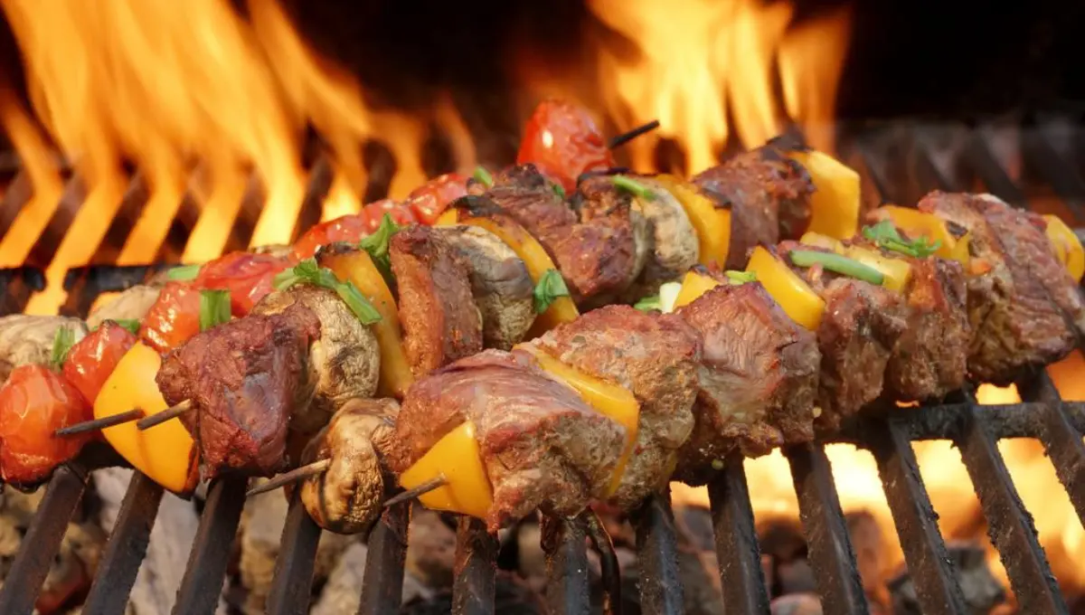 Close-up Of BBQ Tasty Cubed Beef Kebabs With Paprika Slice On The Flaming Charcoal Grill