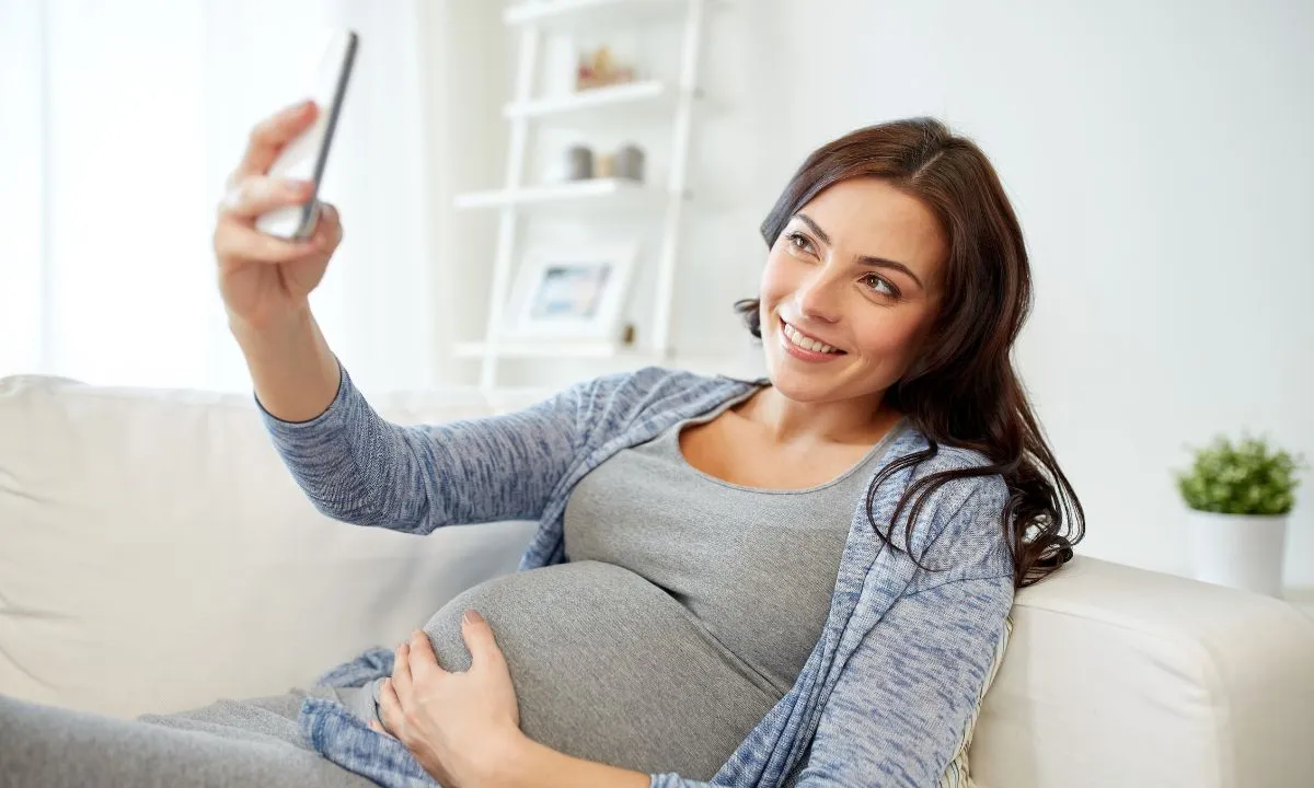 a pregnant woman taking her selfie from a mobile phone
